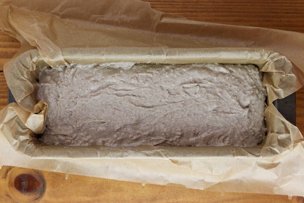 Buckwheat dough in a baking pan, lined with parchment paper.